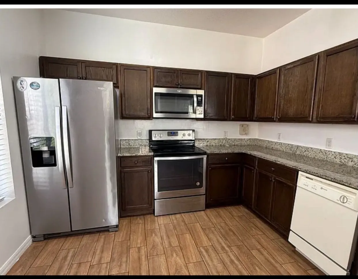 Before: dark espresso kitchen cabinets around a stainless fridge and range