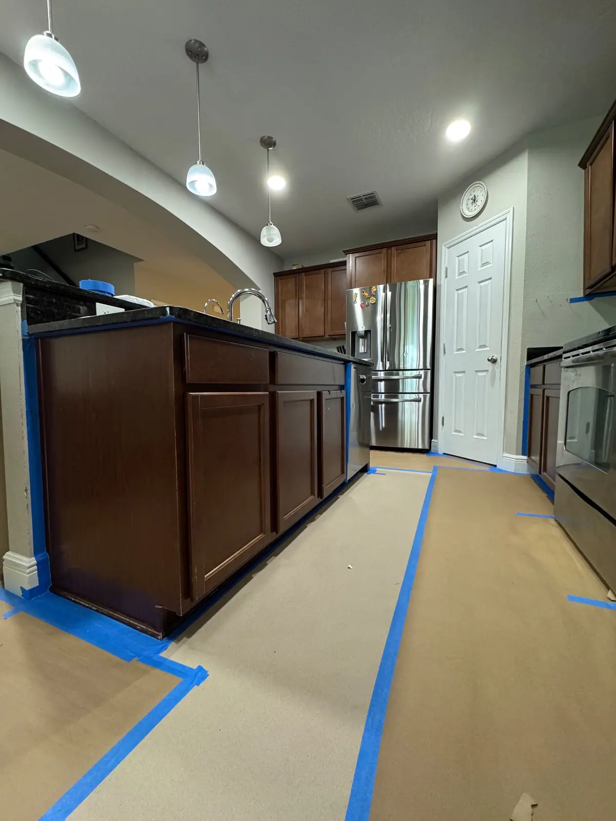 Kitchen island with the floor papered and edges taped before painting