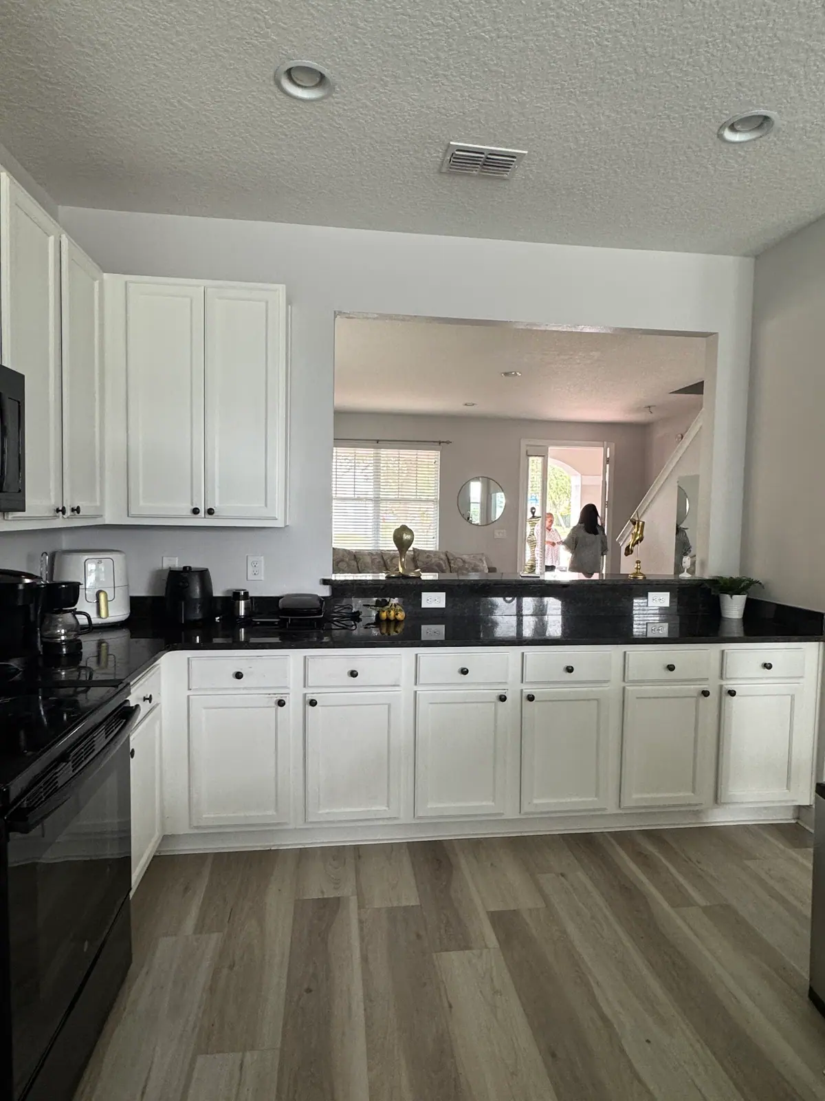 White painted shaker cabinets over black granite counters