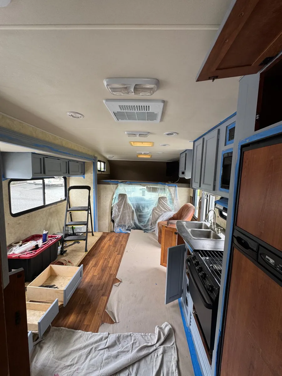 Motorhome with the cabinet doors off, the floor covered and every edge taped